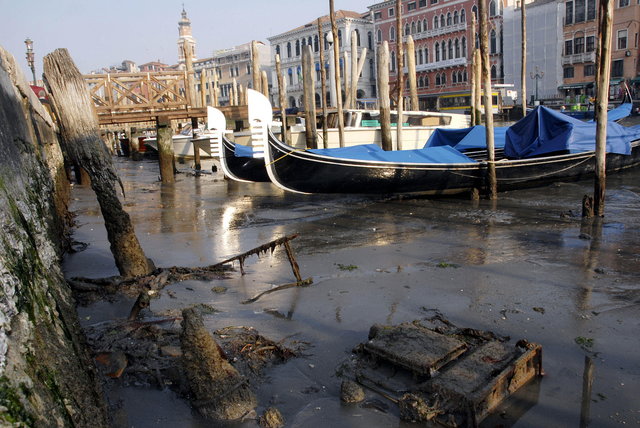 Gondolas are stranded in the mud on February 19, 2008 in a canal in Venice. No gondola rides were on offer in Venice on Tuesday as the canal city known for its struggle with ever-rising water levels was instead left high and dry by an exceptionally low tide.  Some canals were emptied down to their mud bottoms in a phenomenon that is expected to last until the weekend.  AFP PHOTO / ANDREA PATTARO